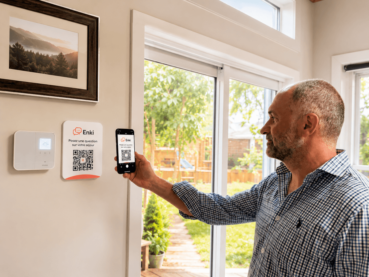 Un voyageur scanne le QR code Enki affiché sur le mur de son logement